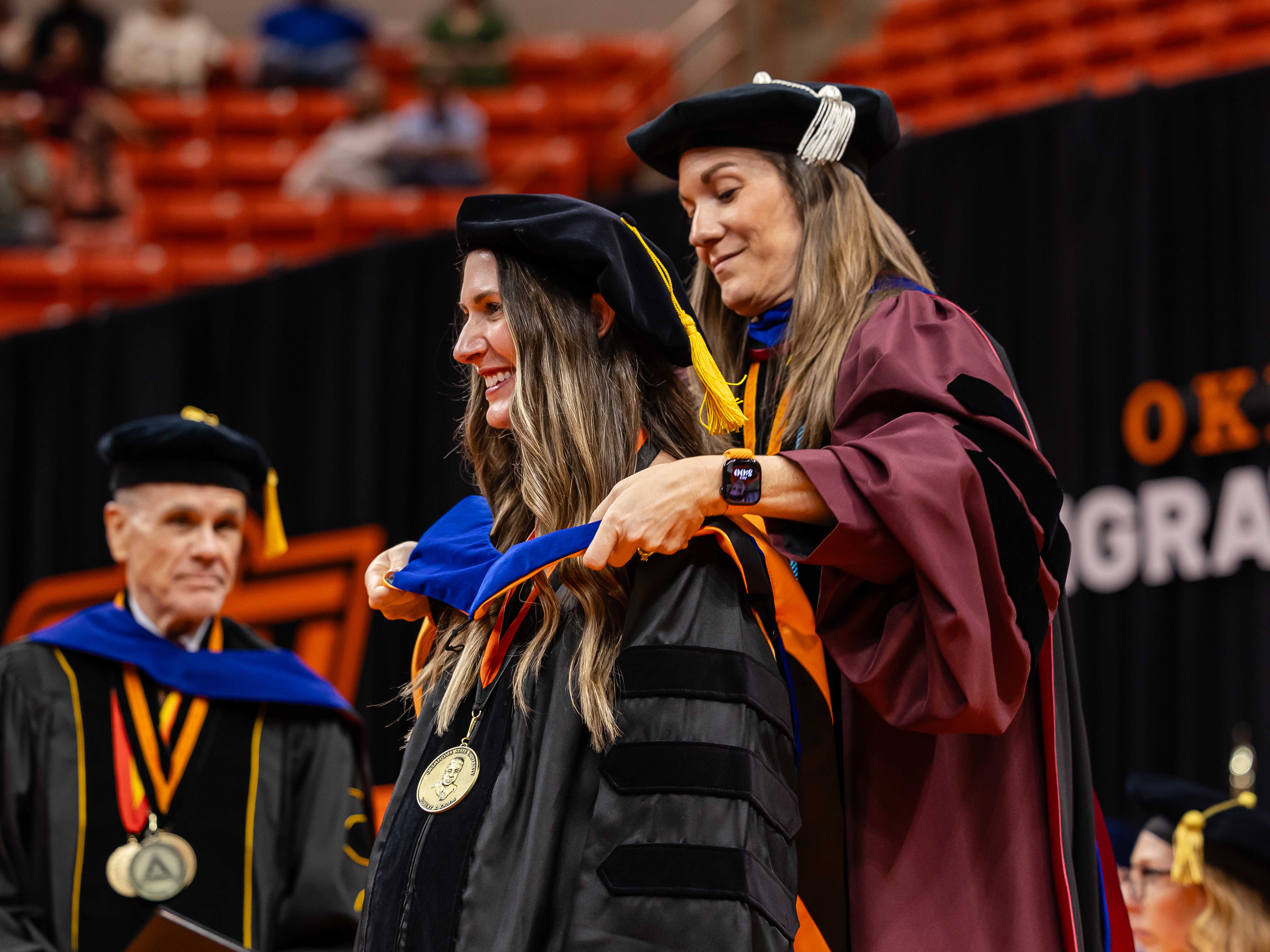 Female professor hooding a female student at commencement. 